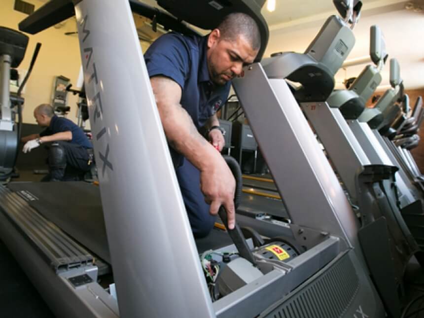 Técnicos reparando caminadora